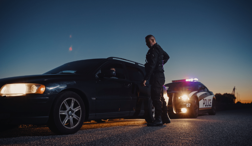 Police officer pulling over a driver at dusk